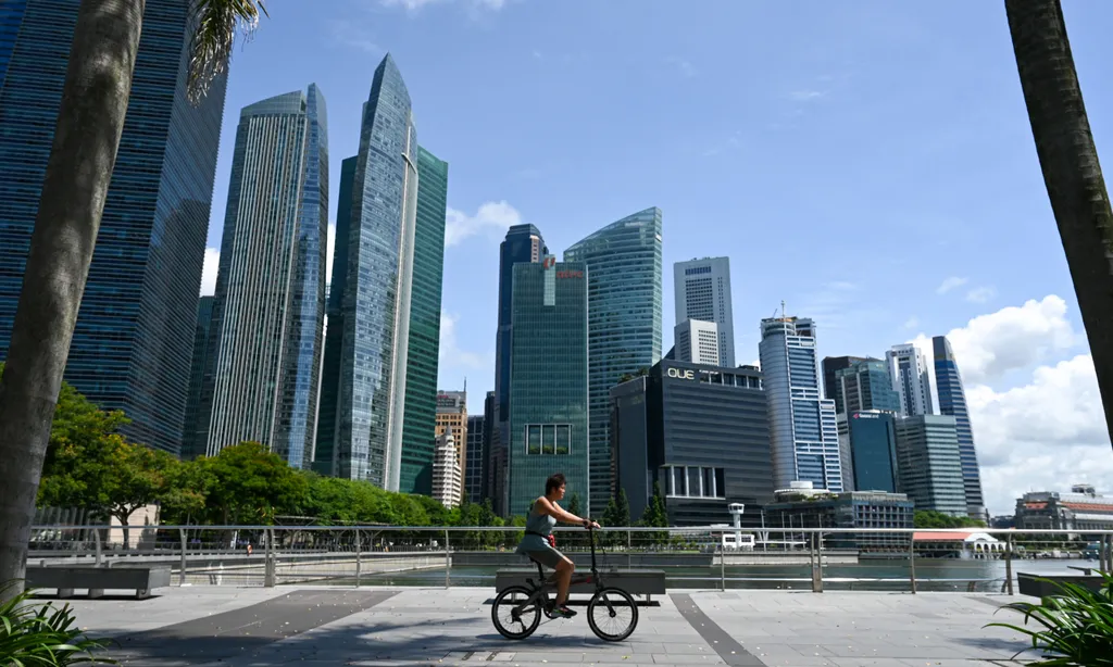 A single cyclist in front of many skyscrapers.