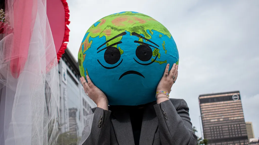 View of an activist wearing a mask representing the planet Earth while protesting Africa Oil Week in Cape Town, South Africa
