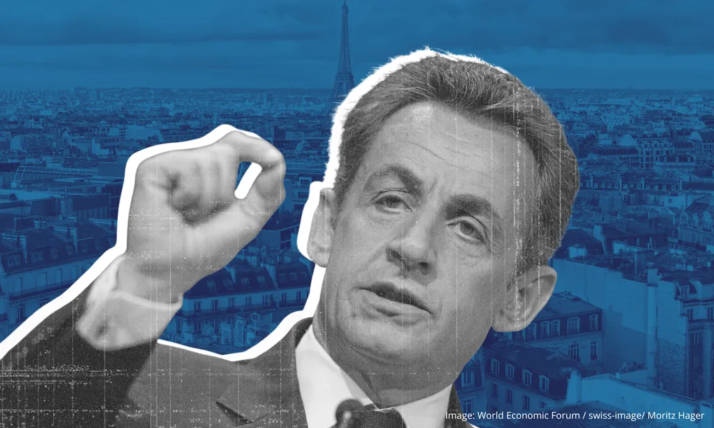 A black and white photo of Nicolas Sarkozy speaking with his fist raised.