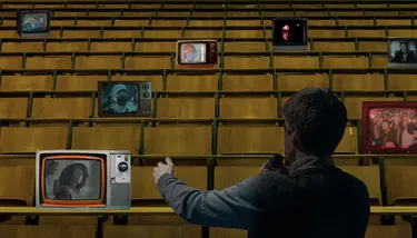 A man addresses a room of screens depicting protests